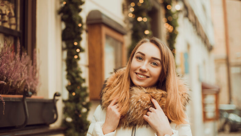 Pretty woman walking in city, beautifully decorated for the Christmas