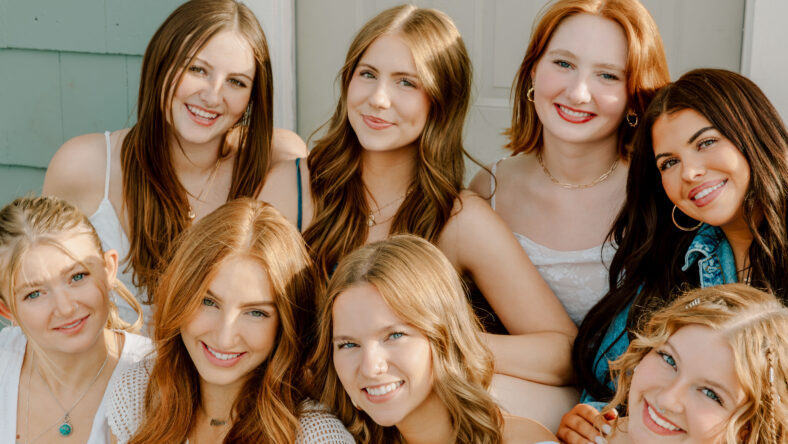 Group of cheerful female college students enjoying time together on campus, representing friendship, education, and youth