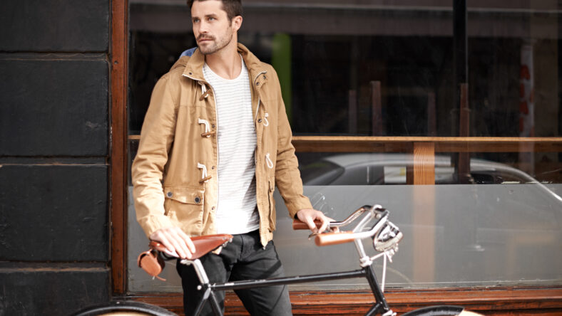 Cropped shot of a fashionable young man walking with his bicycle.