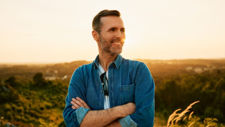 Portrait of smiling adult man on day hike during sunset