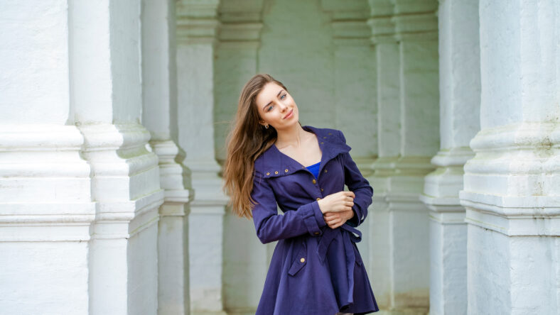 Portrait of a beautiful young brunette woman in dark blue coat