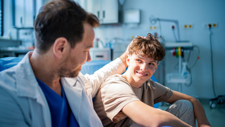 Physician supporting nervous teenage patient during mental health check, before surgery.