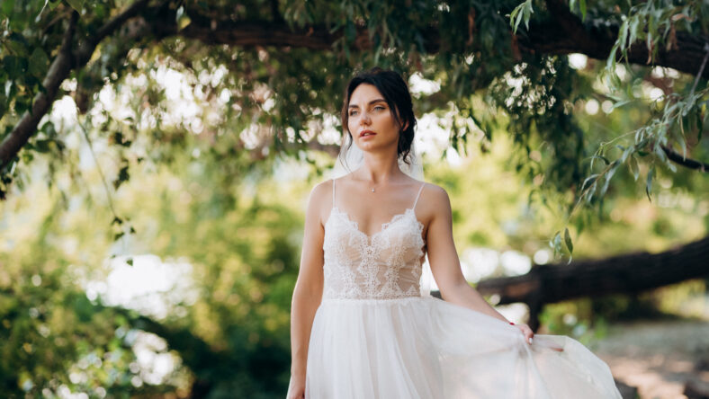 bride blonde girl with a bouquet in the forest in the sunset light