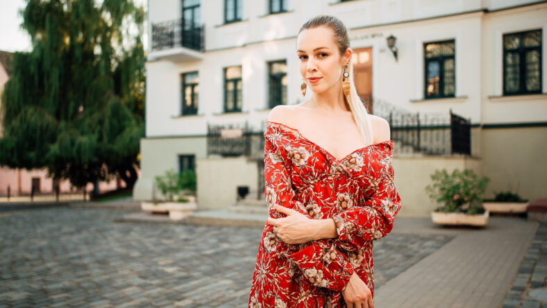 Beautiful young girl in a red dress outdoors, portrait of a stylish woman