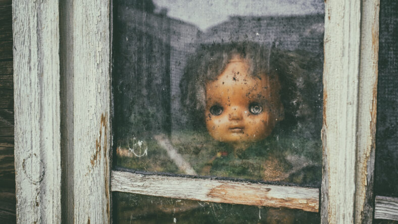Ghost mystic doll smiling. Scary horror plastic