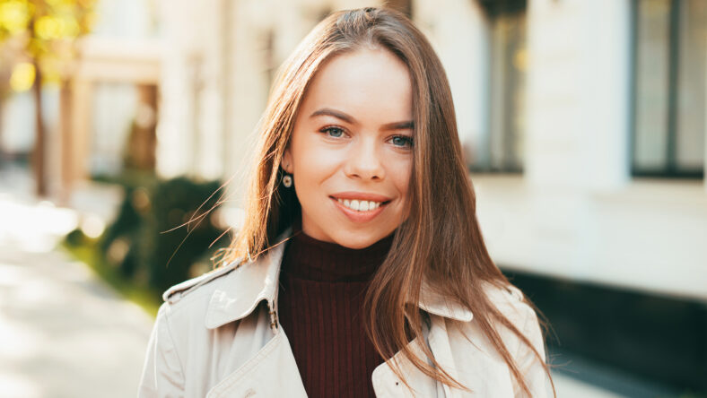 Close up portrait of beautiful smiling young woman outdoor during autumn.