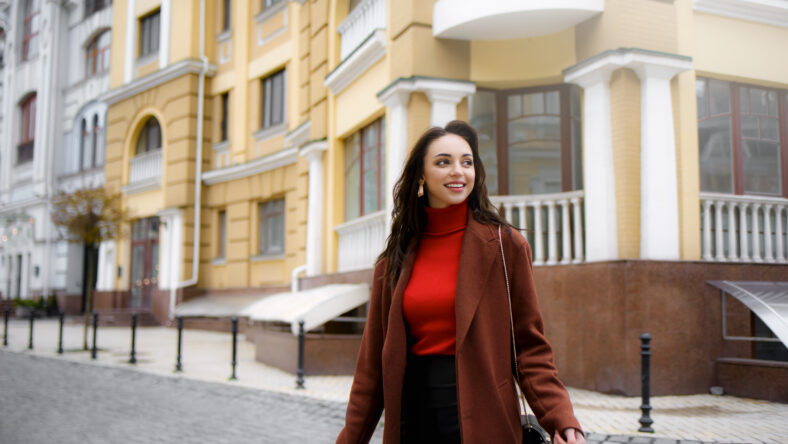 Smiling, stylish woman crossing the street in a hurry to work