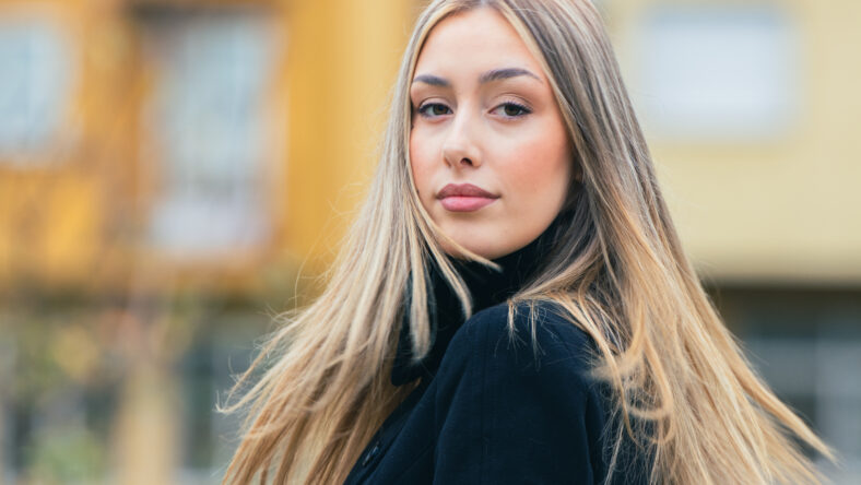portrait of a young woman with long blonde hair on the street