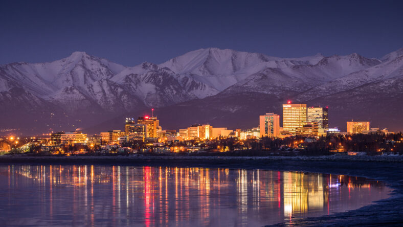 Anchorage city lights reflecting on Cook Inlet at twilight