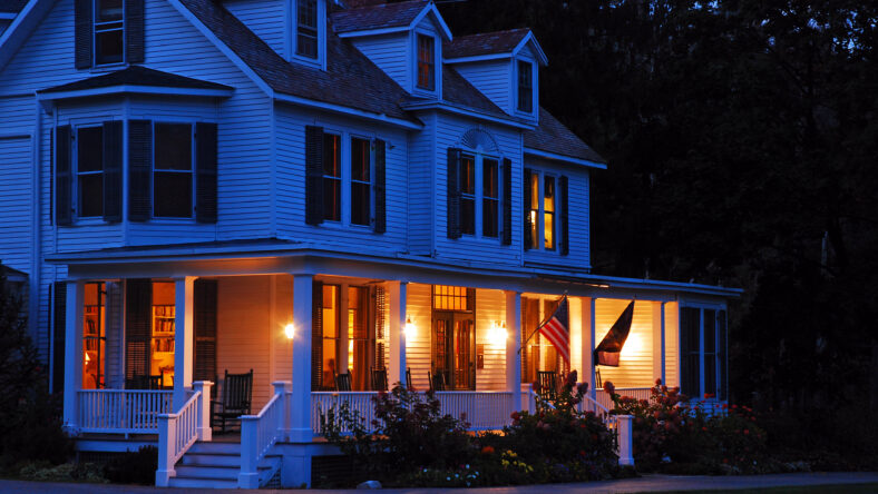 A suburban home is lit at dusk
