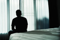 Silhouette depressed man sadly sitting on the