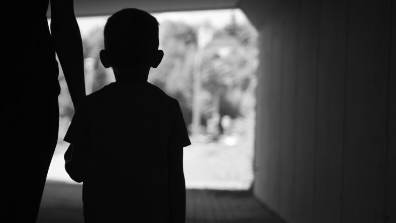 Mother child walking in urban dark city street