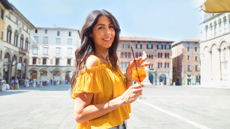 Beautiful young woman drinking aperol spritz in Italy