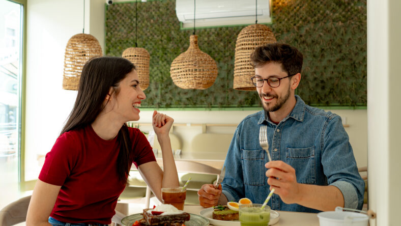 Young Couple Enjoying Brunch and Conversation at Trendy Restaurant