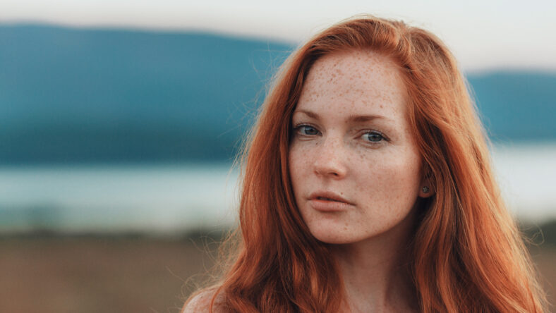 Positive natural close up portrait of young gorgeous caucasian ginger girl with freckles. Healthy lifestyle, beauty, natural concept. Melancholic beautiful portrait