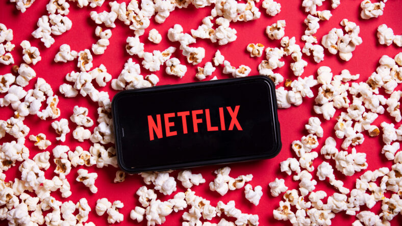 Netflix logo on a smartphone with popcorn