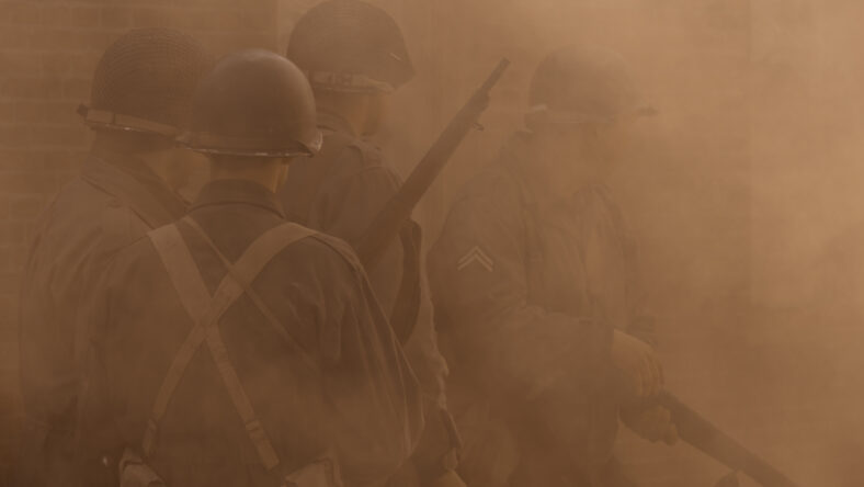 American Soldiers in world war two uniform, covered by smoke and ready to enter the battlefield