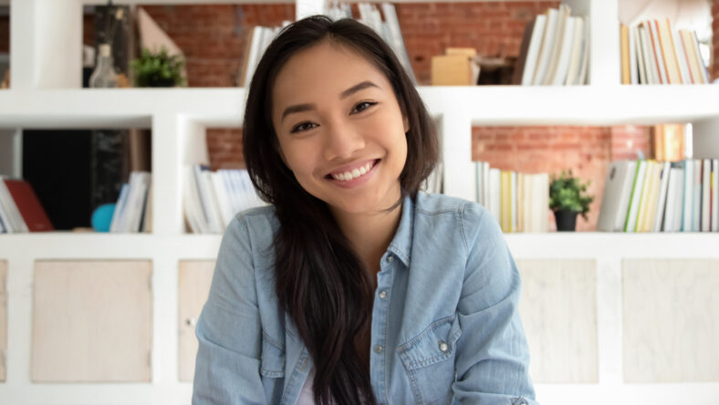 Smiling asian young woman looking at camera webcam making distance video conference call for online job interview or teaching, happy asian teen girl student teacher vlogger recording vlog, portrait