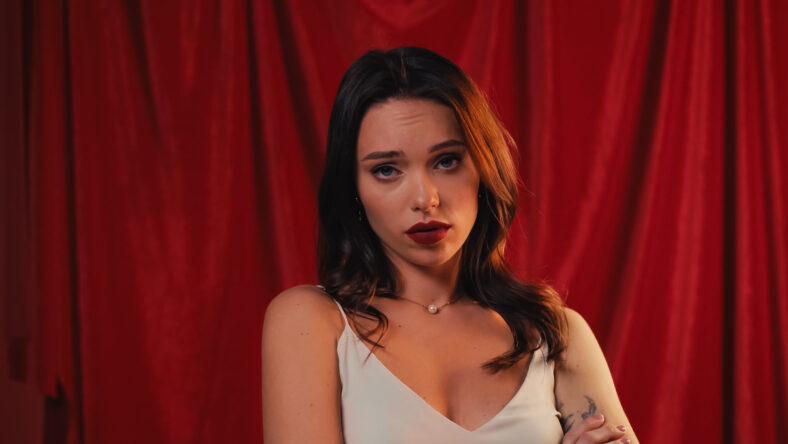 young and displeased woman looking at camera on red,stock image