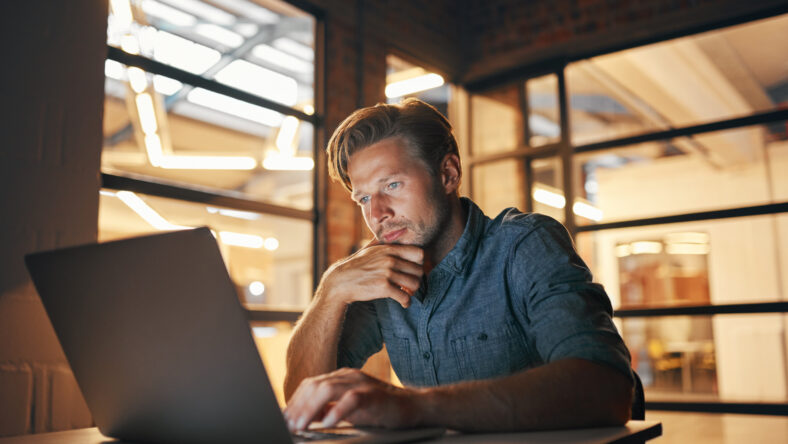 Shot of a handsome young man working late in his office.