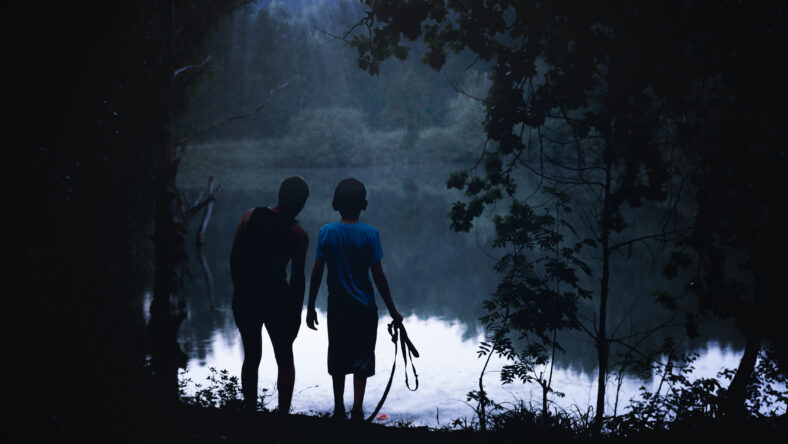 people are looking in the woods and on the riverbank. Adventures of teenagers