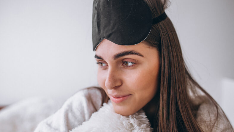 Woman in bed wearing sleeping mask