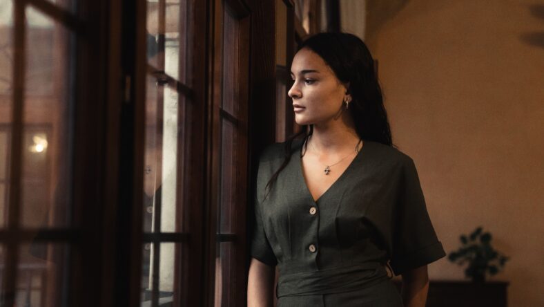 Beautiful closeup of a brunette woman next to the window