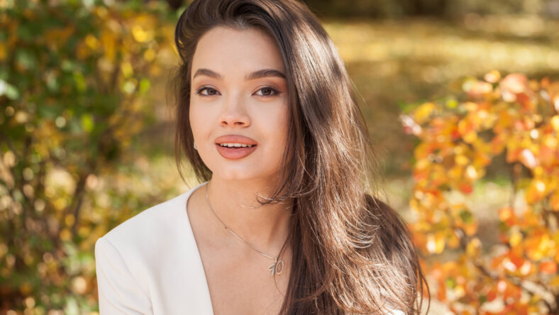 Close up beautiful asian kazakh brunette woman in autumn park