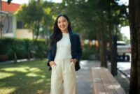 Young Asian woman smiling with hands in
