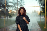 cute red-haired curly girl rejoices under the