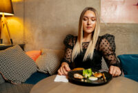 Young beautiful girl having dinner in the