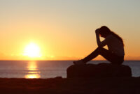 Sad woman silhouette worried on the beach