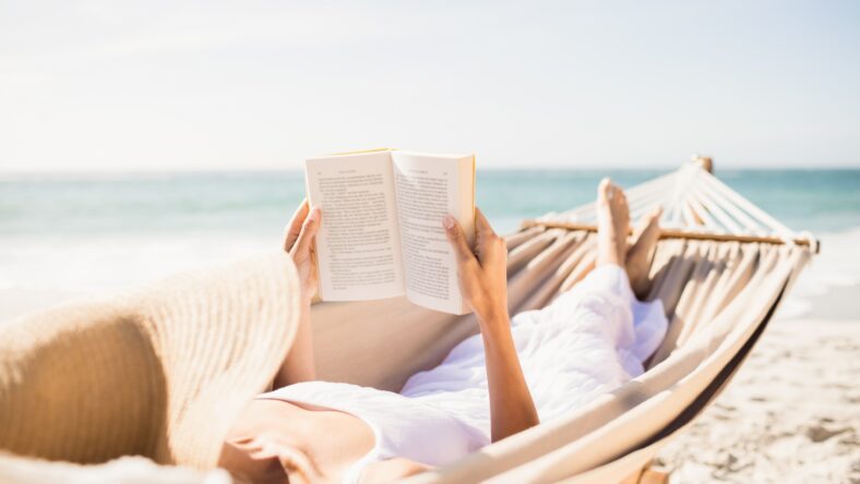 Woman reading book in hammock