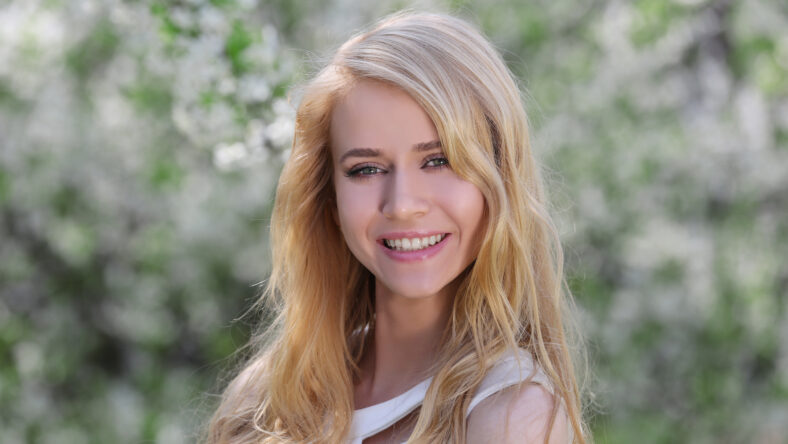 Young beautiful woman on blooming tree background