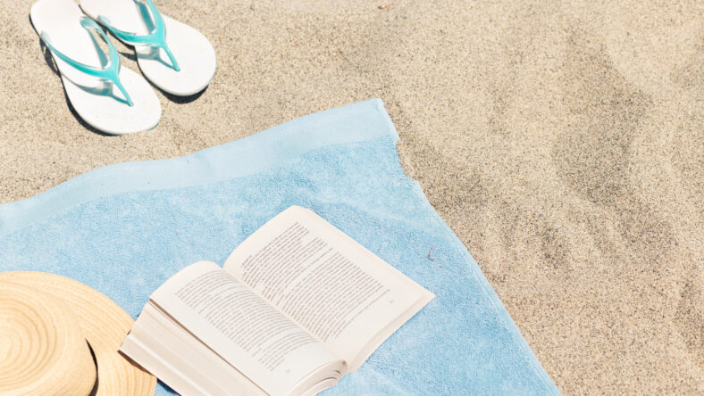 book on the beach sand with a towel