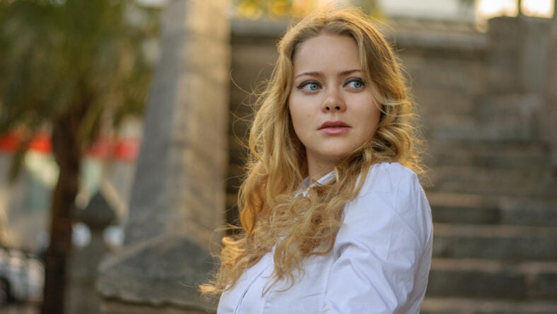 beautiful blond woman in white posing, stairs