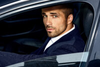 handsome man in costume inside the car