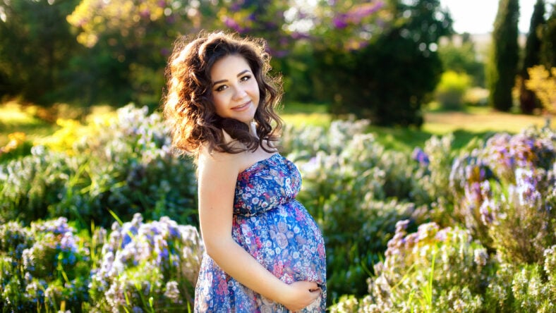 Outdoor portrait of young pregnant woman in