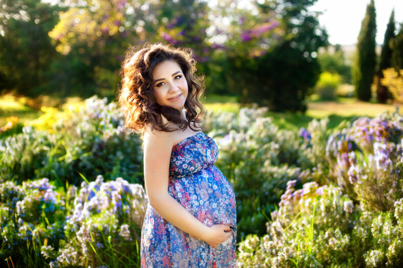 Outdoor portrait of young pregnant woman in