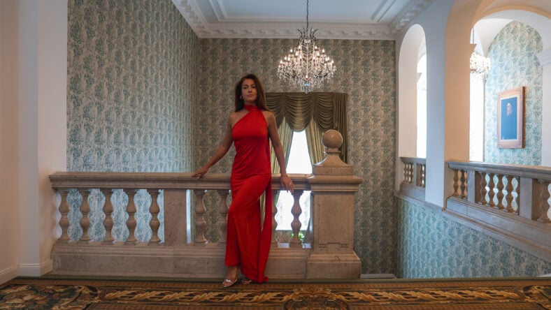 A woman in a red dress stands