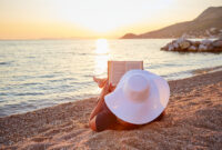 Woman reading a book on the beach