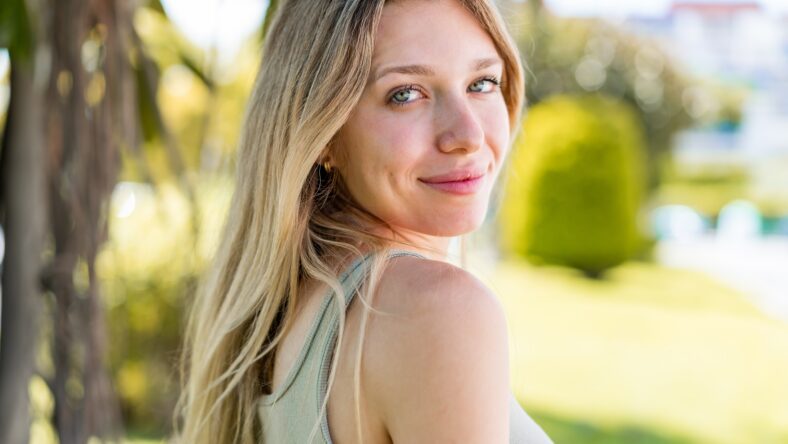 Young blonde woman at outdoors . Portrait