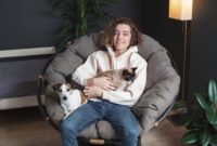 Happy young man sitting on sofa with