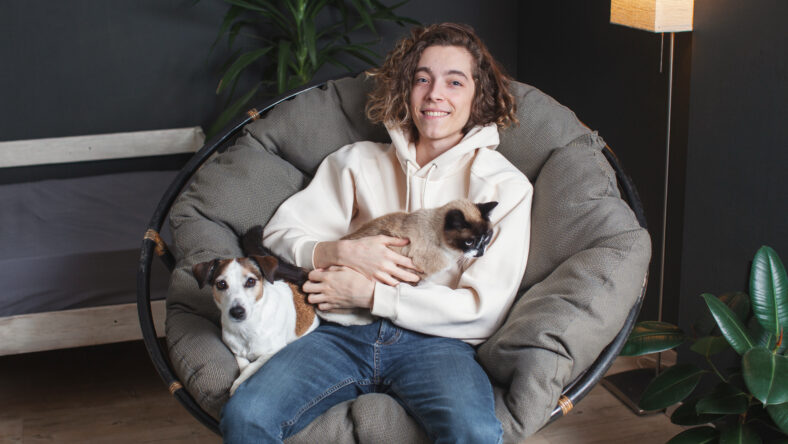 Happy young man sitting on sofa with