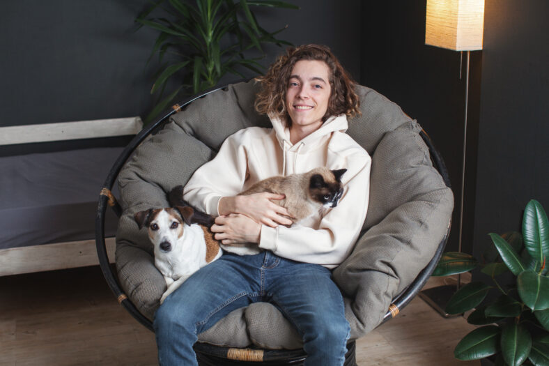 Happy young man sitting on sofa with