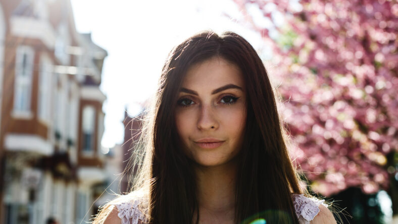 Charming young woman in pink dress poses