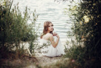 beautiful boho girl sitting on sandy beach