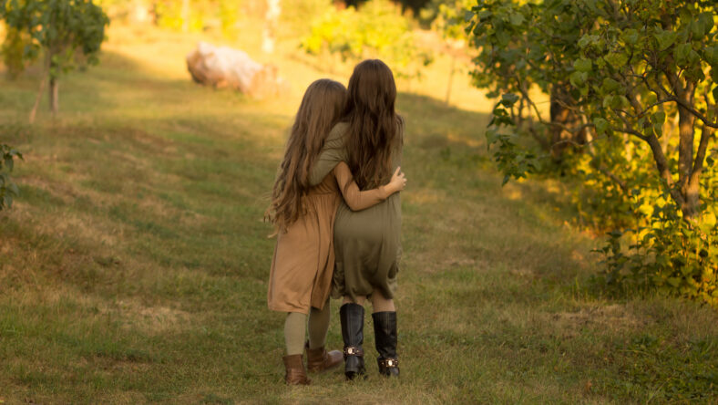 two girls hug on the street in