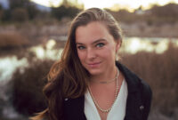 woman wearing mens waistcoat poses by a