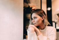 Cute blonde girl sits in a cafe